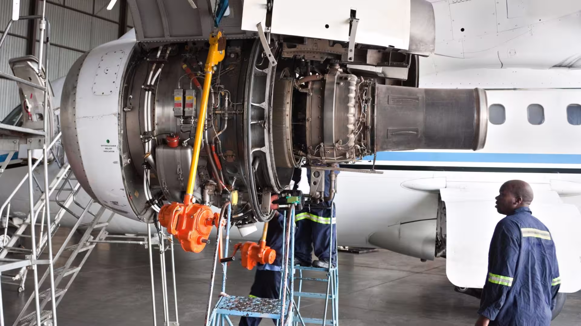 Engineers servicing an aircraft engine on a maintenance stand