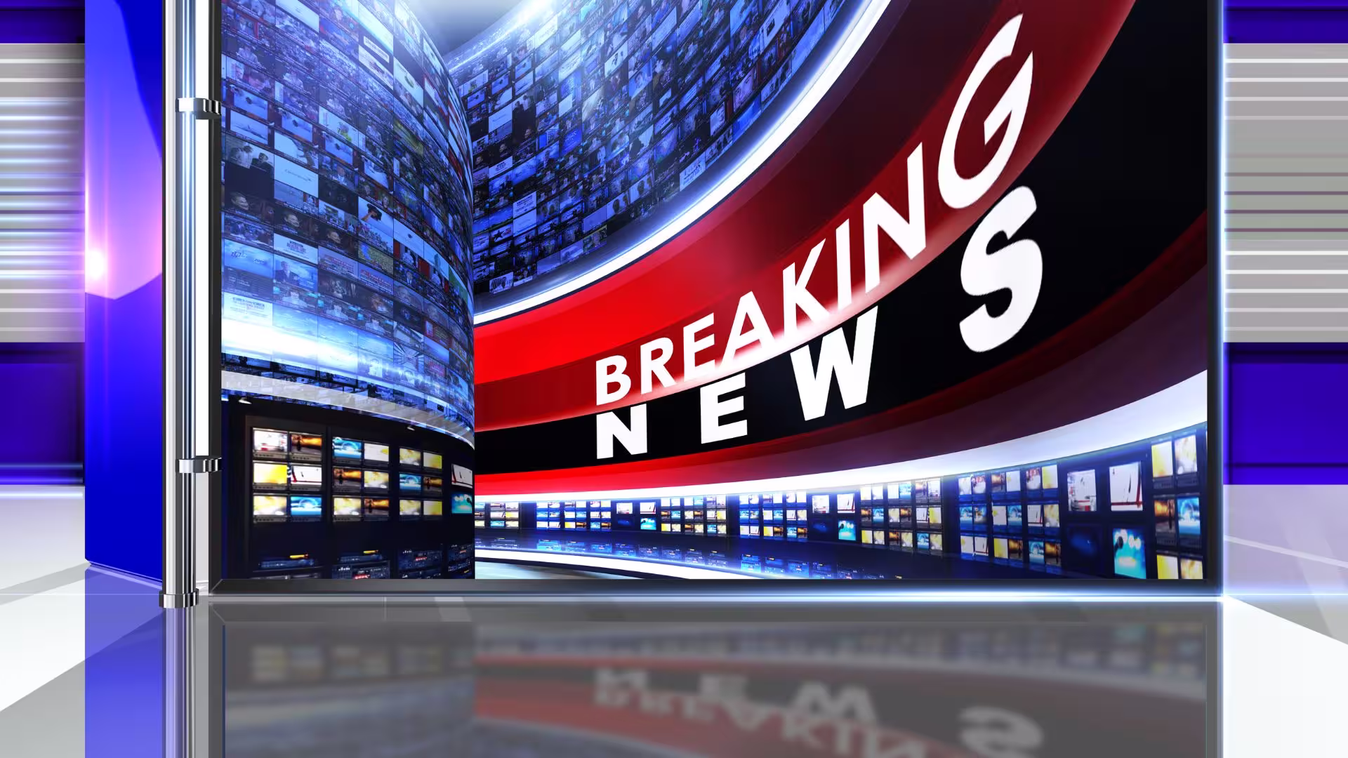 A broadcast studio wall of screens showing a breaking news graphic