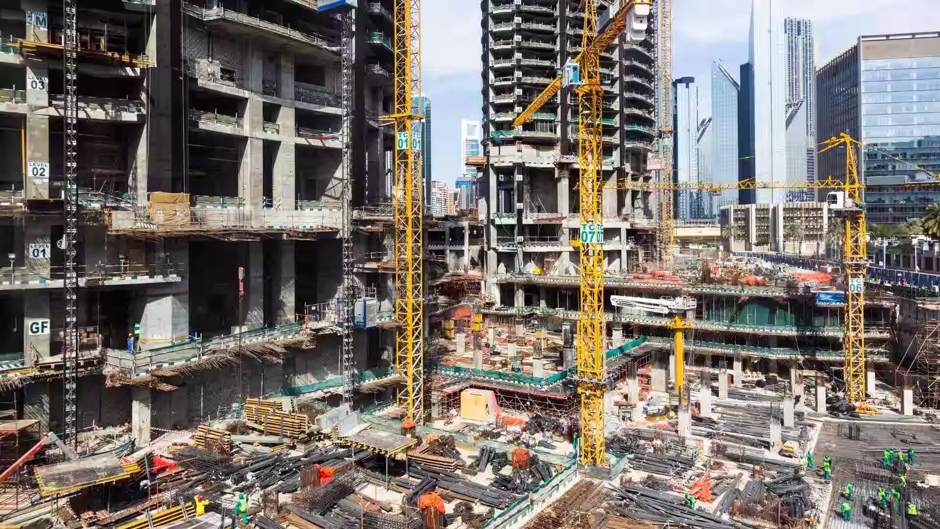 A large construction site with tower cranes and stacked building materials