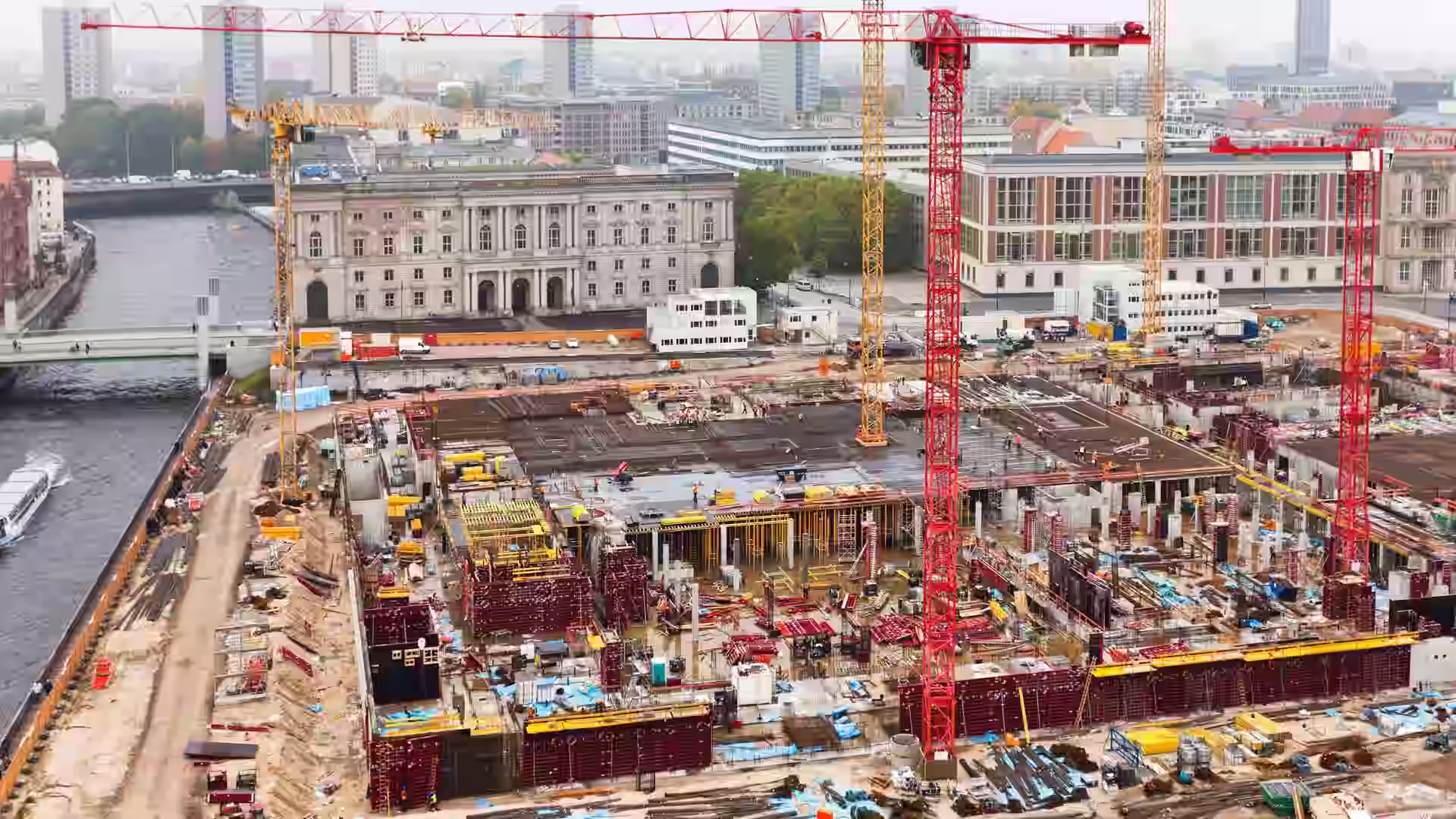 An aerial view of a city construction site with cranes and formwork